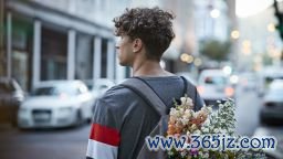 Young man on the street with flower in rug sack